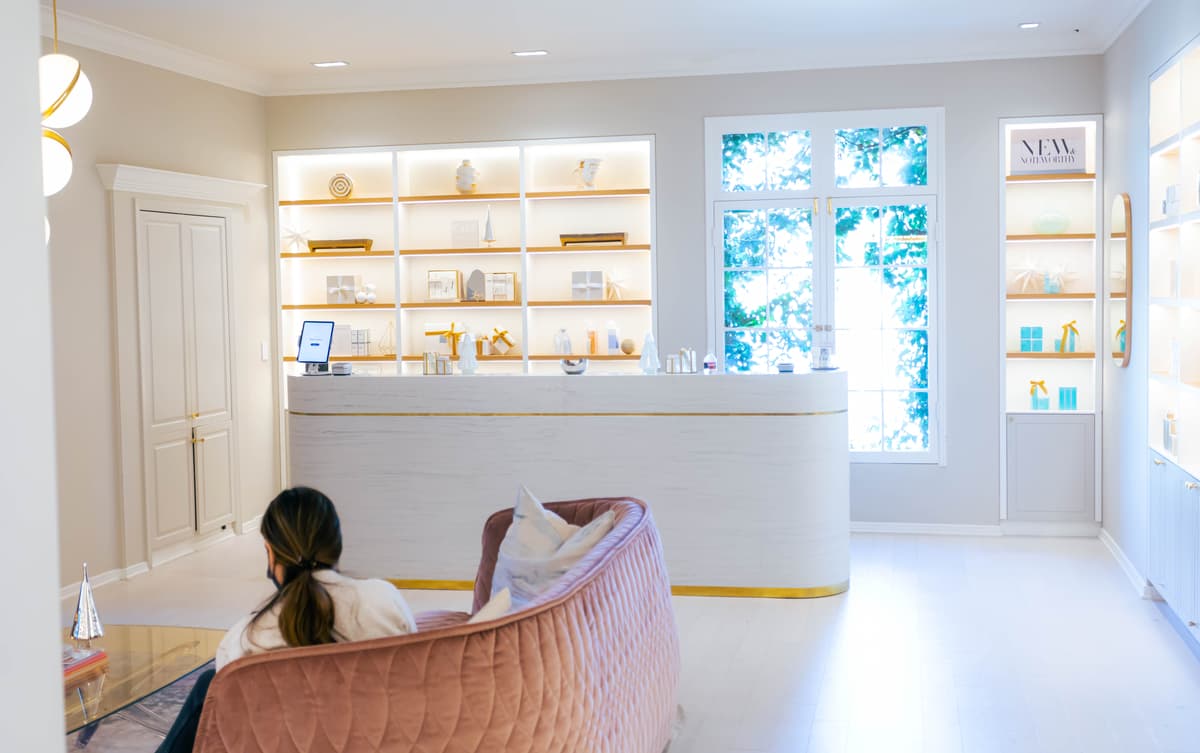 A client waits on a couch in a spa waiting room.